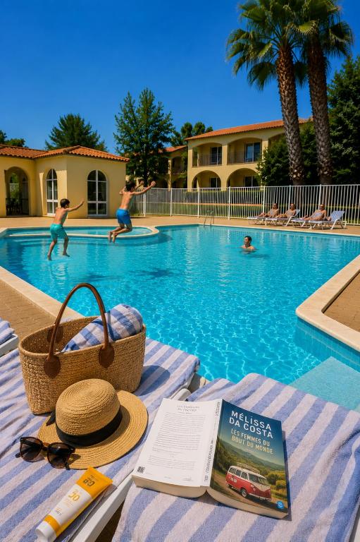 a swimming pool with a hat and a book and people in the water at Horizon Bleu Canet in Canet-en-Roussillon