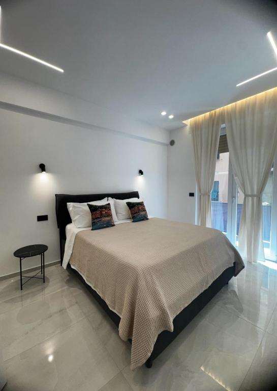 a bedroom with a large bed with white walls and windows at Maison Miry in Rapallo