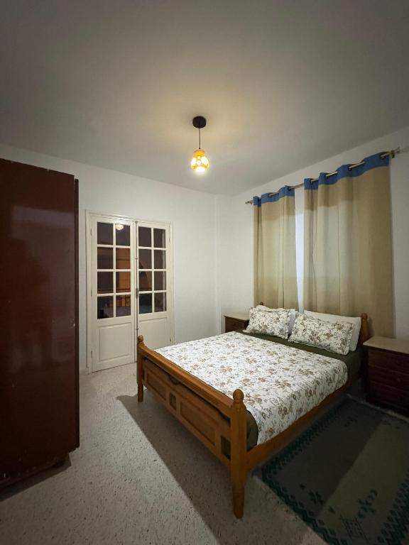 a bedroom with a bed and a television in it at Dar KAMOUN - 2BR Apts with 5G WiFi & Parking, Houmt Souk & Corniche in Houmt Souk