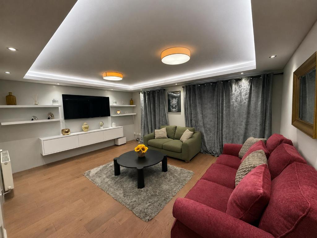 a living room with a red couch and a tv at Right Choice by 3 Crowns in Dundee