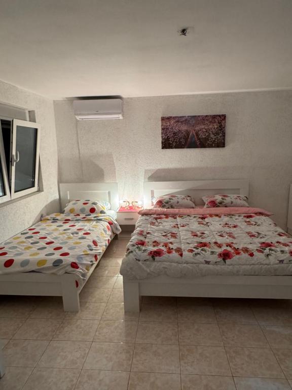 a bedroom with two beds with flowers on them at Apartmani Kruče in Ulcinj