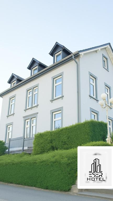 a white building with a sign in front of it at ESER Hotel Pension in Beuggen