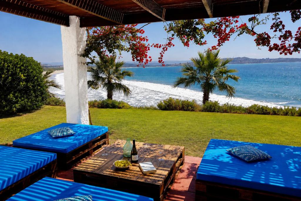 a patio with blue benches and a view of the beach at Puerto Velero/ Primera Linea in Puerto Velero