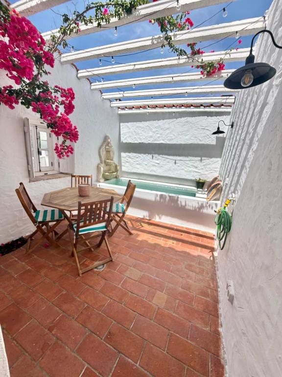 a patio with a table and chairs and flowers at Casa Alma Clara in Odemira