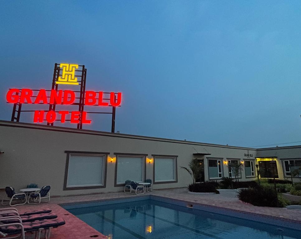 a hotel with a sign and a swimming pool at Grand Blu Hotel in Hyderabad