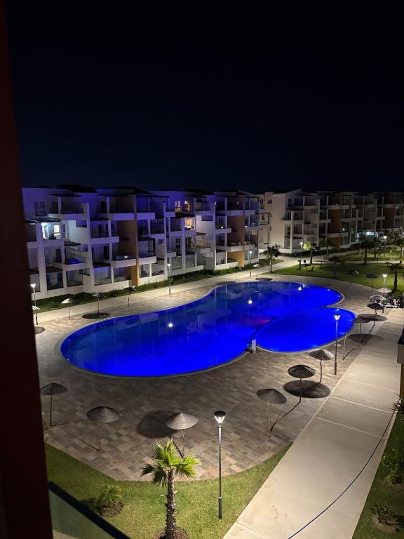 a large blue swimming pool in front of a building at New Luxury apartment with 3 pool in Cabo Negro