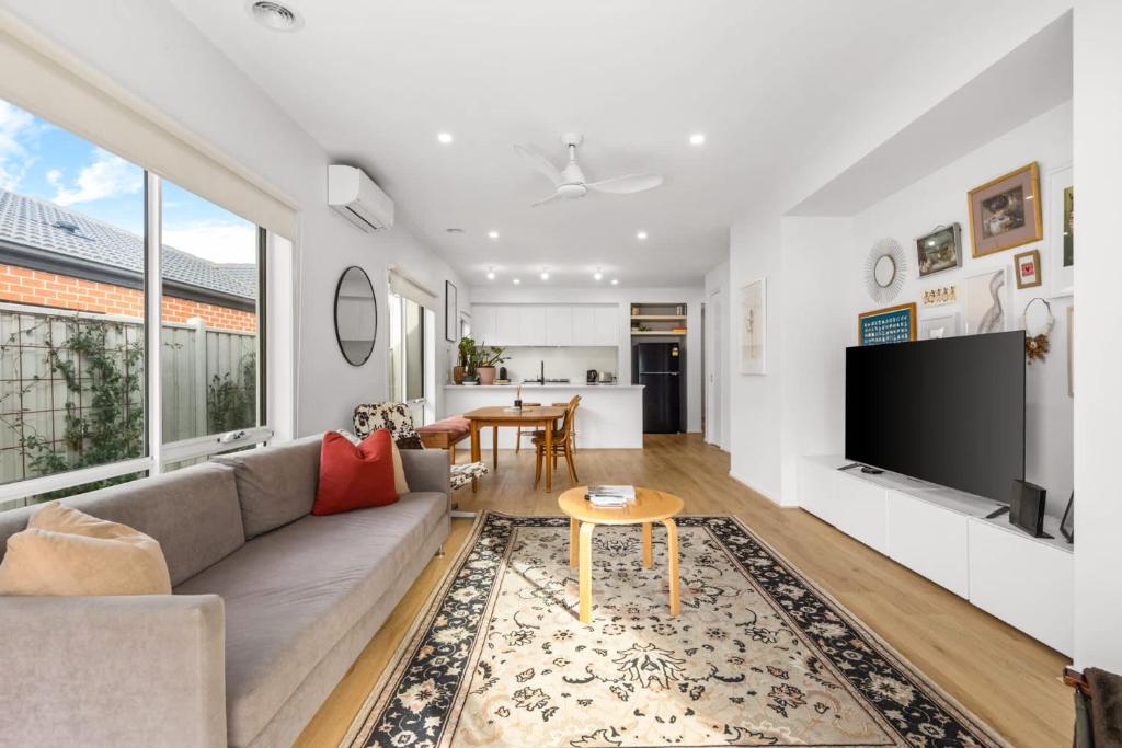 a living room with a couch and a tv at 3BR Light-filled Retreat Mt Duneed in Mount Duneed