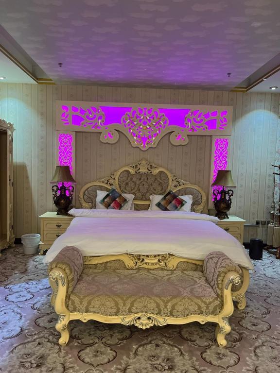 a bedroom with a large bed with a purple ceiling at فندق رفايا الشاطيء in Jazan