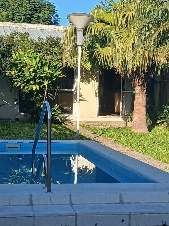 a pool in front of a house with a palm tree at Rendel in Paraná