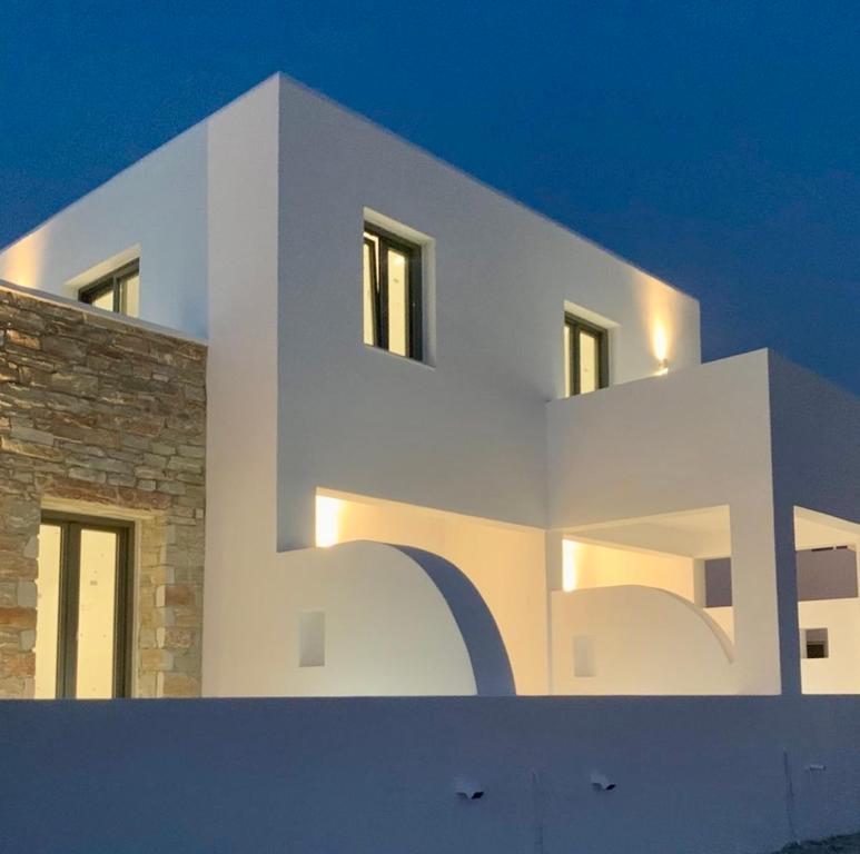a white building with a large letters on it at AiΘeria Suites Ios in Ios Chora
