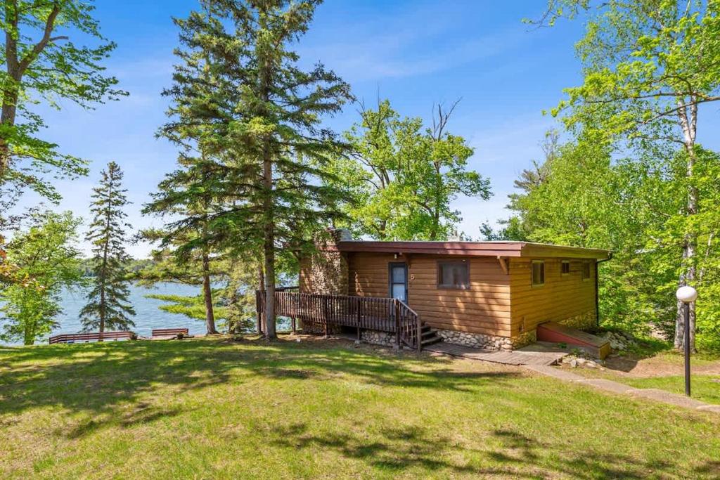 a cabin in the woods with a view of the water at Cabin #5 3BR 2BA Timberlane Resort in Park Rapids