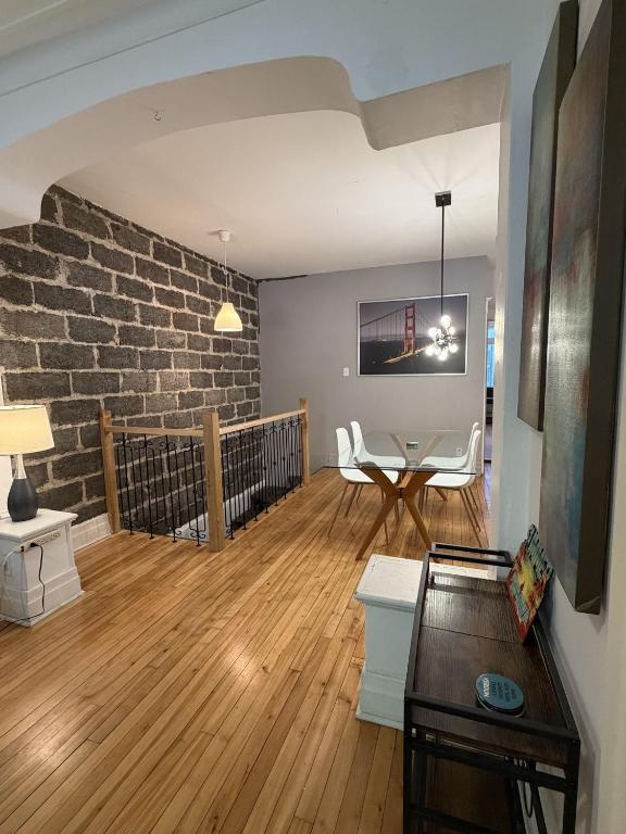 a living room with a table and a brick wall at Verdun Beach, House in Montreal