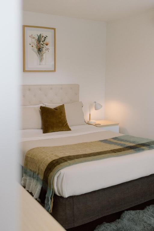 a white bedroom with a large bed in it at Riverside retreat, Wanaka in Albert Town