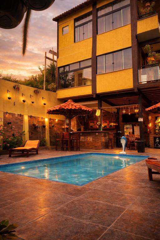 a swimming pool in front of a building at Pousada Mirante Pôr do Sol in Maricá