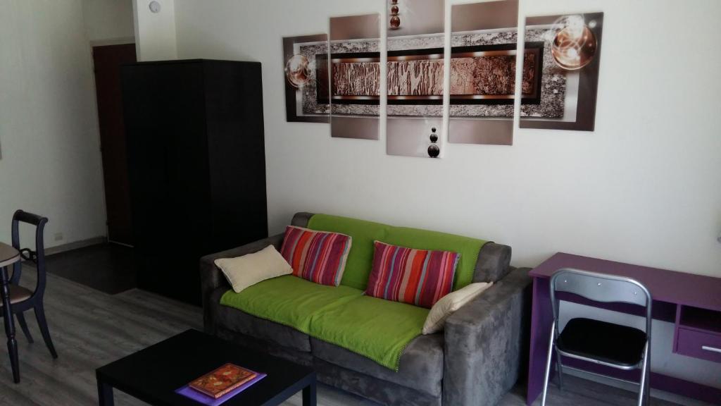 uma sala de estar com um sofá verde e uma mesa em Appartement Porte Évêque em Avignon