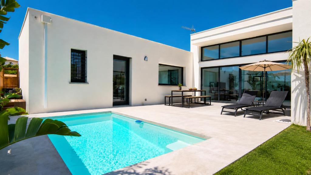 a swimming pool in the backyard of a house at Oasis Blue Perpignan Canet in Perpignan