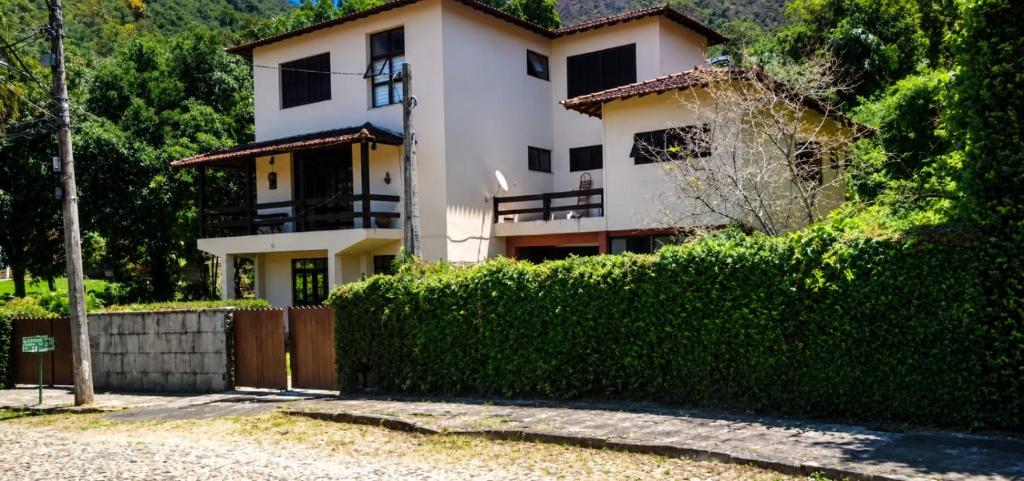 a house with a hedge in front of it at Suíte Pimenteiras in Teresópolis