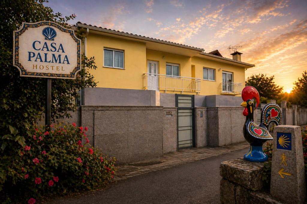a building with a sign in front of a house at Casa Palma Hostel in Barcelos