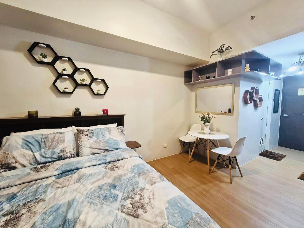 a bedroom with a large bed and a table at The Loop Towers Limketkai in Pontud