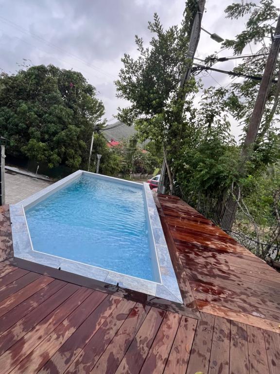 a swimming pool on top of a wooden deck at Villa Tidodo in Les Anses-dʼArlets