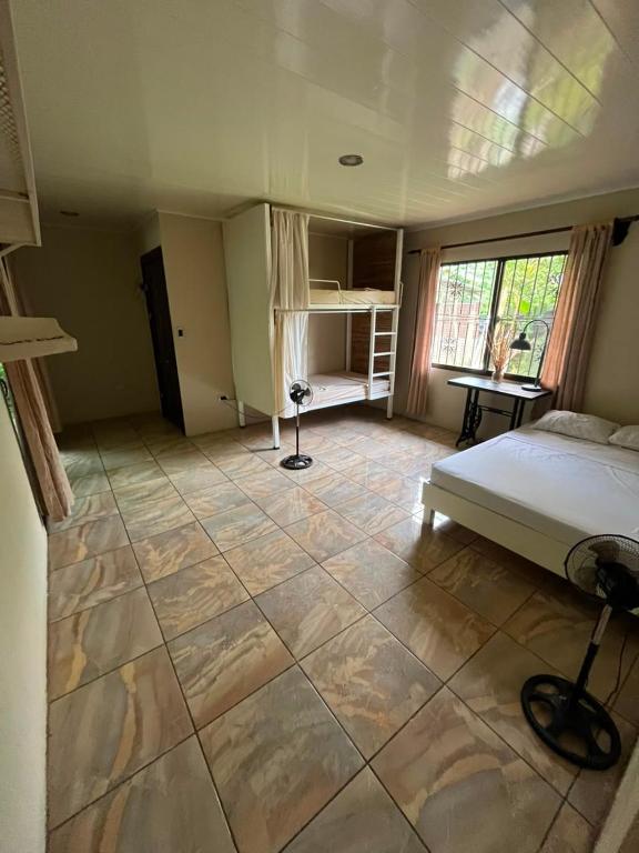 a bedroom with a bed and a tiled floor at La casa de MR in Sarapiquí