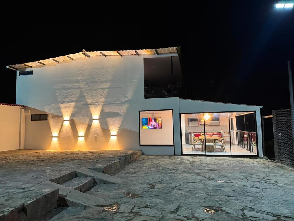 a building with lights on the side of it at night at House premium in Macanal