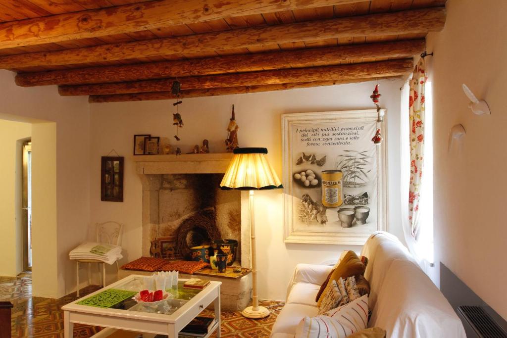 a living room with a white couch and a fireplace at Dormire alla Ruota in Negrar