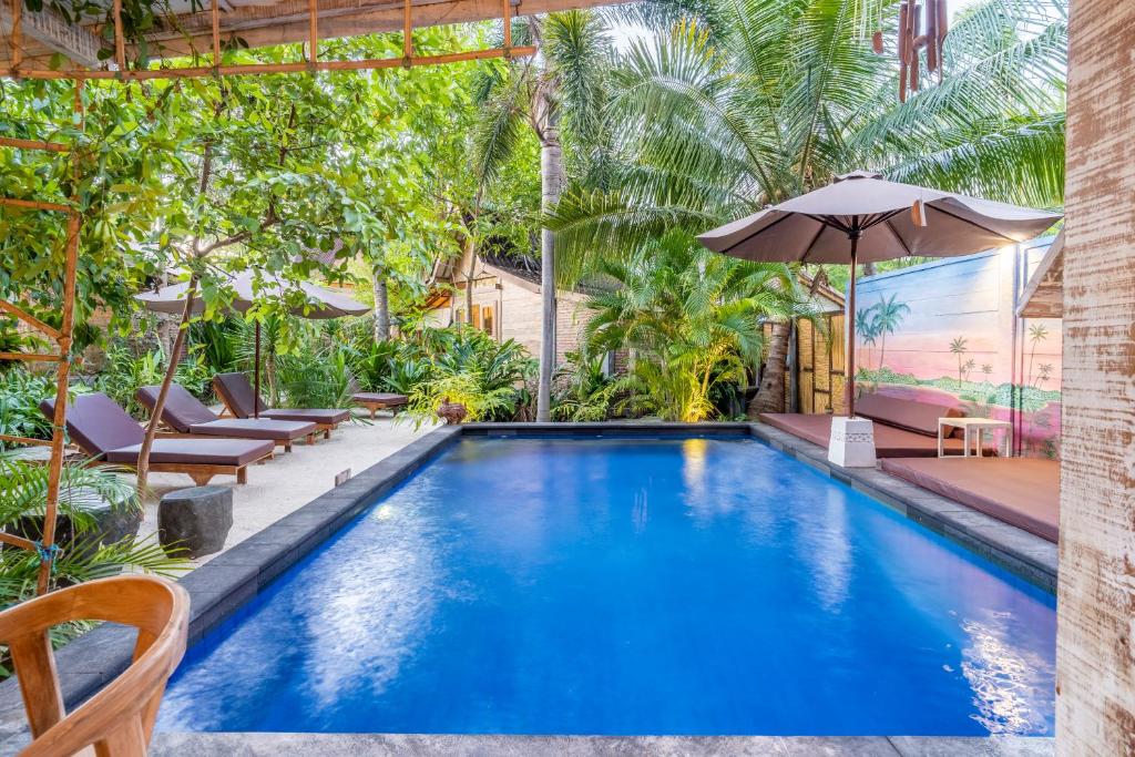 an infinity pool with chairs and an umbrella at Ortigia Tropical Lodge in Gili Trawangan