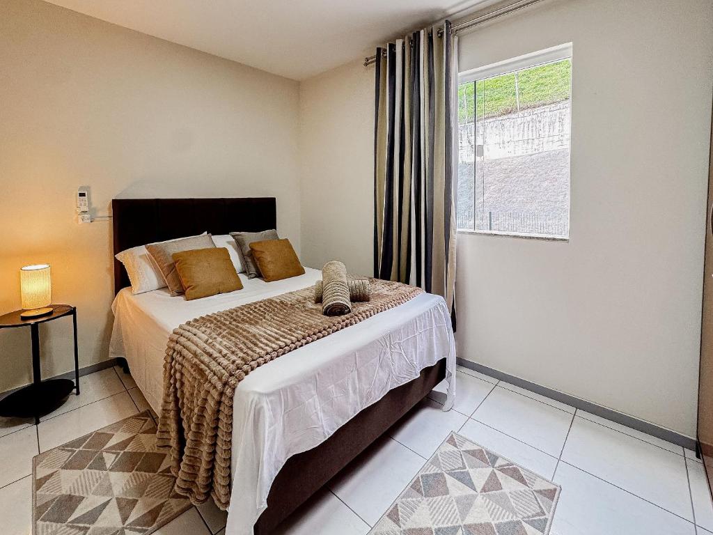 a bedroom with a bed and a window at Centro, apê 2 Quartos com Ar | Garagem in Brusque