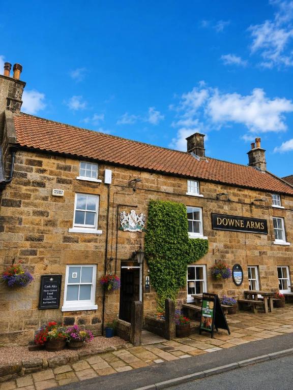 a building with a sign that reads doozy arms at The Downe Arms Inn in Castleton