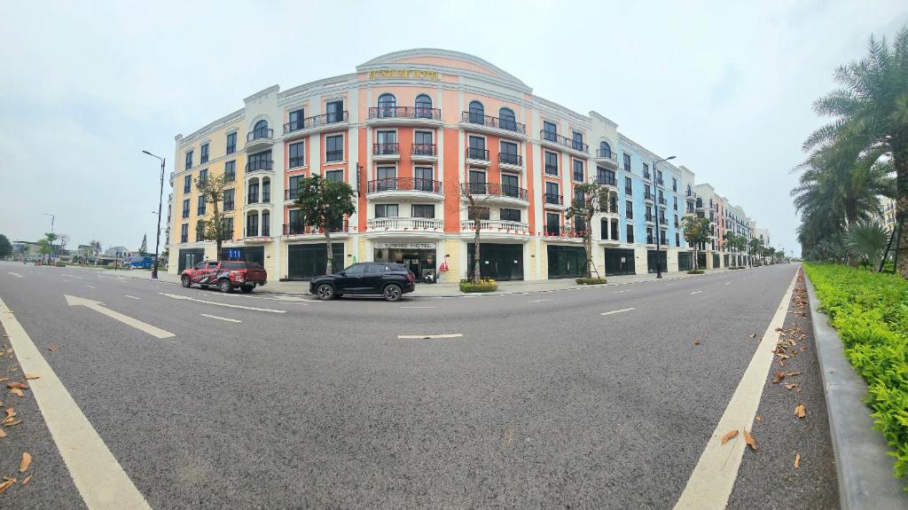 a large building with cars parked on the side of a street at Sunrise Hotel Tại Sầm Sơn in Thanh Hóa