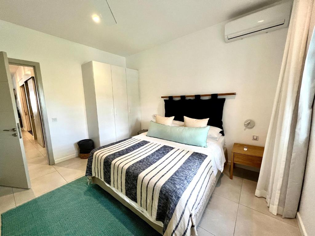 a bedroom with a bed with a black headboard at Eastern Blue Beachfront Apartment in Poste Lafayette
