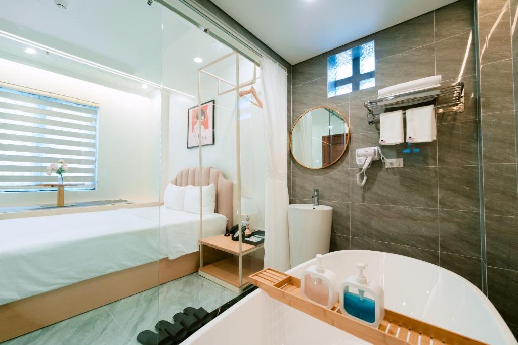 a bathroom with a bed and a tub and a sink at Nhật Tân Hotel Triển Lãm VEC - Đông Anh in Dong Anh