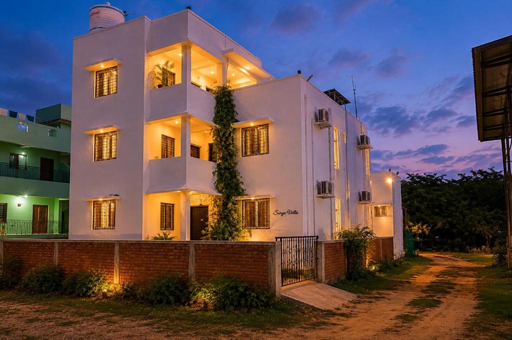 a white house at night with lights on at Surya Villa Guesthouse in Auroville