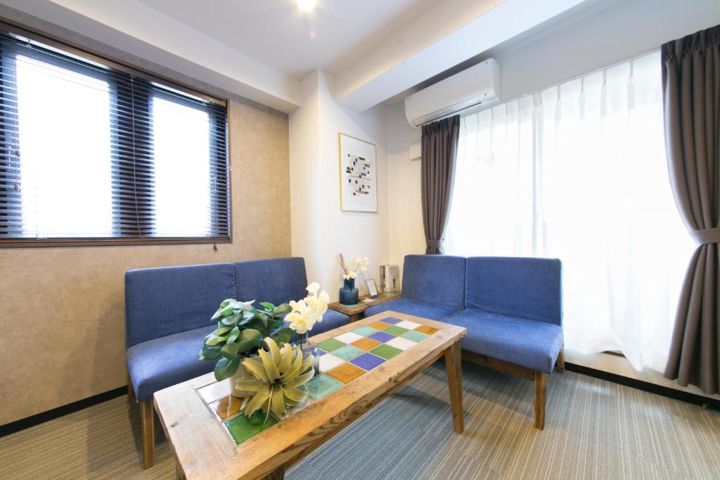 a living room with blue chairs and a table at AI Annex in Osaka