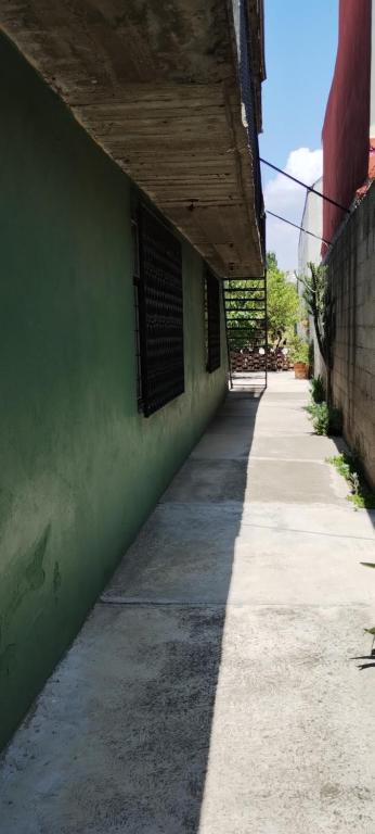 an empty sidewalk next to a green building at Céntrico, seguro, tranquilo y limpio in Ocotlán