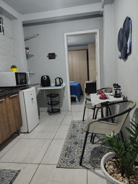 a kitchen and living room with a table and chairs at Casa da Bebel in Uruguaiana