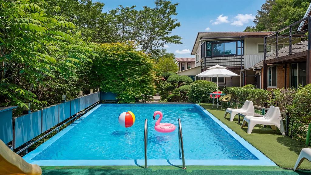 a swimming pool with two pink flamingos in it at Gapyeong ebenzer Pension in Gapyeong