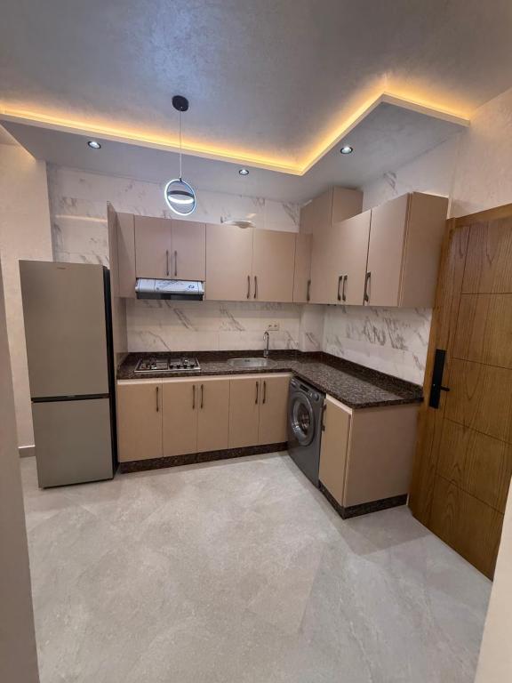 a kitchen with a refrigerator and a washer at اقامة هبة 5 in Yebha