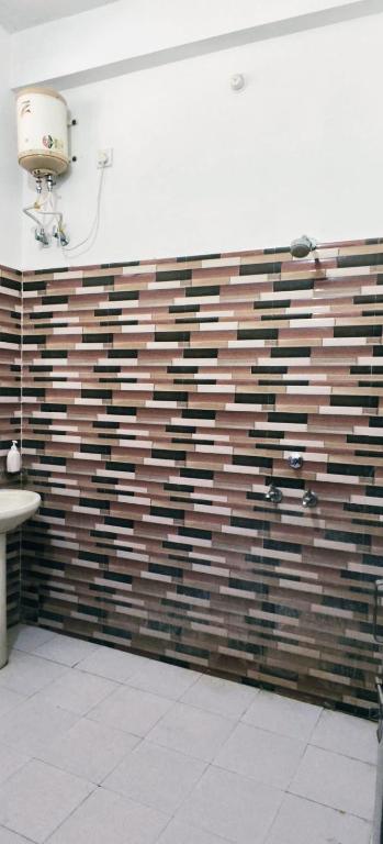 a bathroom with a wall made of wooden blocks at Guru kripa hotel and restaurant in Nīmri