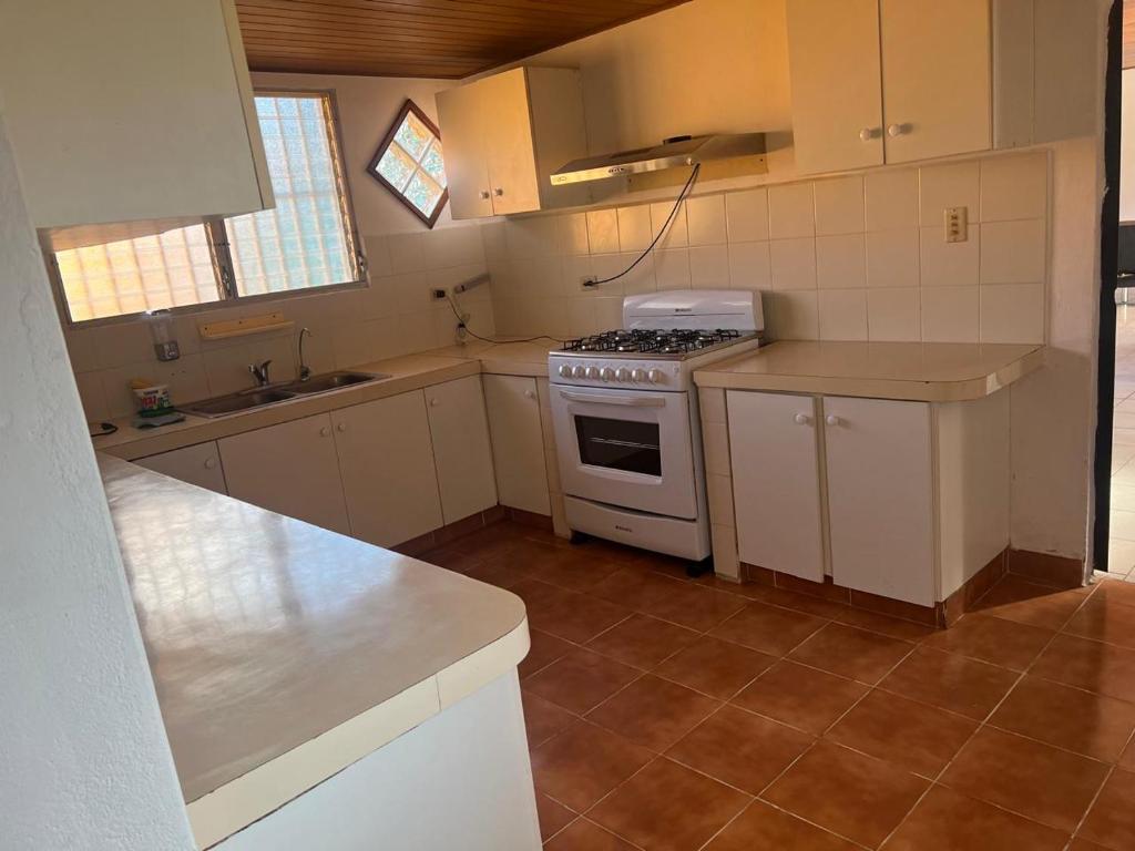 a kitchen with white cabinets and a stove top oven at Casa naranjita in Chame