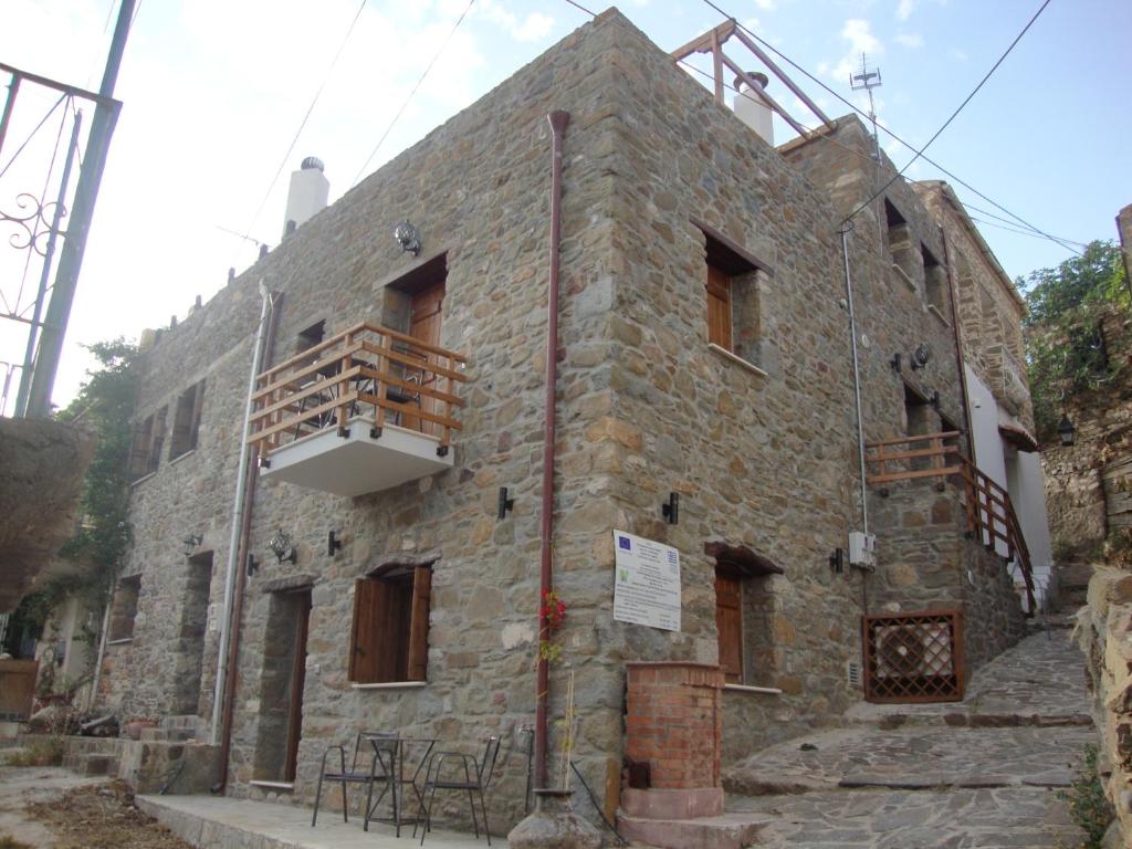 VolissosにあるVolissos Homesのバルコニー付きの古い石造りの建物