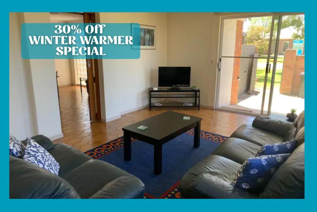 a living room with a couch and a coffee table at Quaint Hideaway in Portarlington
