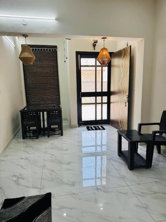 a living room with a table and chairs and a door at Forest breeze villa in Jalandhar