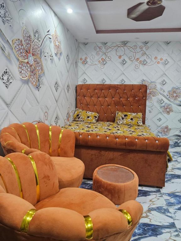 a living room with a couch and two chairs at New aalbayan hotel in Lahore