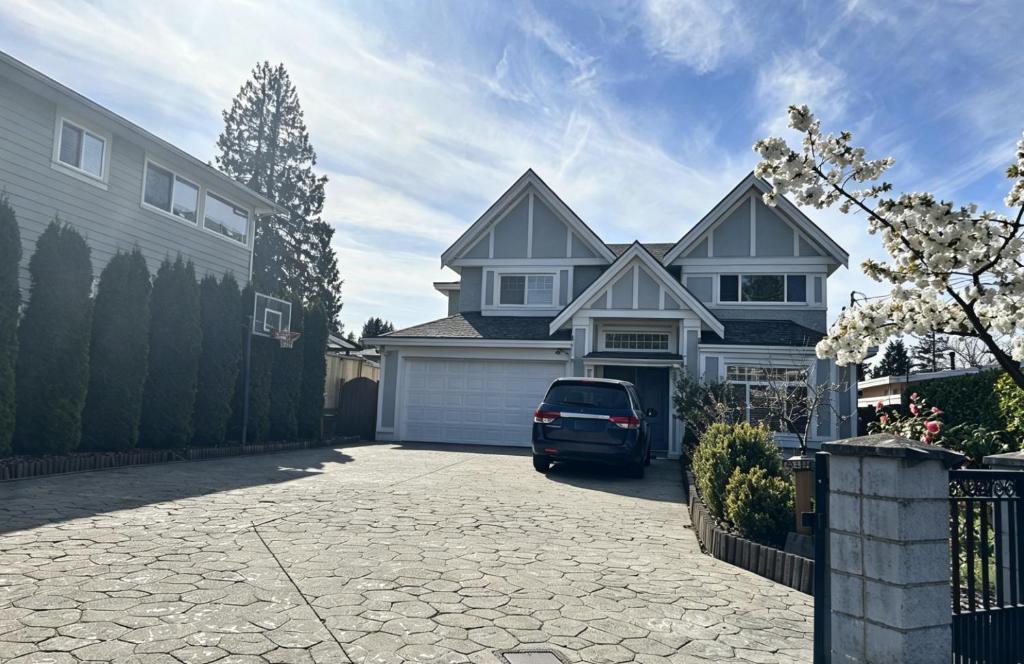 a house with a car parked in a driveway at Spacious 2 Bedroom Suite in Burnaby Free Parking, Full Kitchen, Near Transit in Burnaby