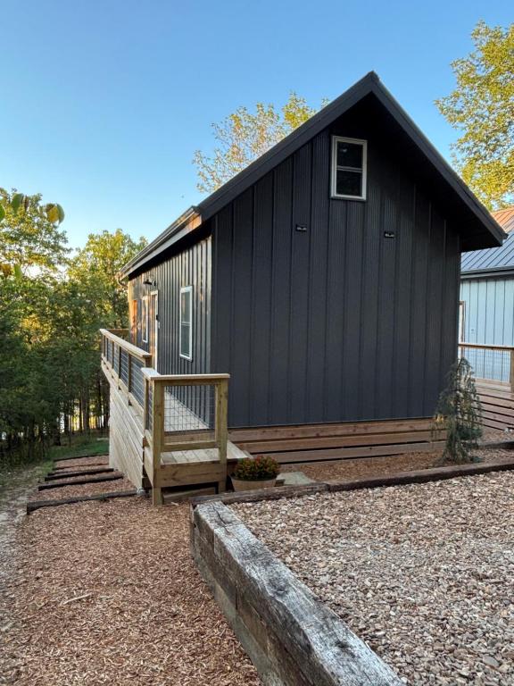 a black house with a bench in front of it at Camptown Cabin in Eagle Rock