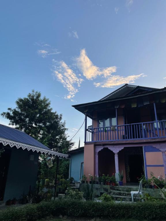 a pink house with a balcony on top of it at Pakha Dhim Heritage Homestay in Namchi