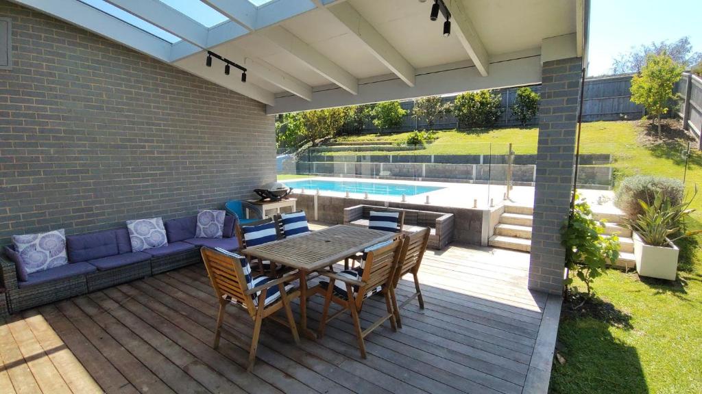 a patio with a table and chairs and a pool at Tea Tree Poolside Escape in Inverloch