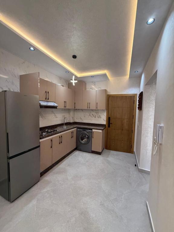 a kitchen with a refrigerator and a dishwasher at اقامة هبة in Yebha